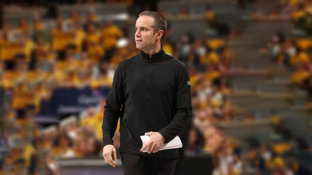 Jordan Ott, newly appointed head coach for the Phoenix Suns, is seen here, during his time as an assistant coach, with a focused expression.