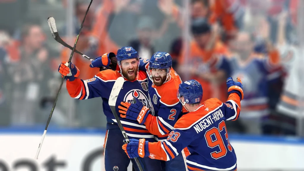 Leon Draisaitl celebrates with Evan Bouchard and Ryan Nugent-Hopkins of the Edmonton Oilers after scoring during the first overtime period against the Florida Panthers in Game One of the 2025 Stanley Cup Final.