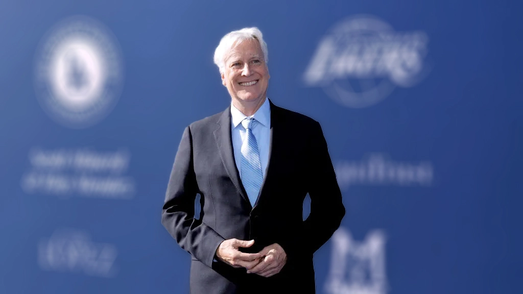 Mark Walter, co-owner of the Dodgers and soon-to-be majority owner of the Lakers, wearing a suit and tie and smiling at the camera.