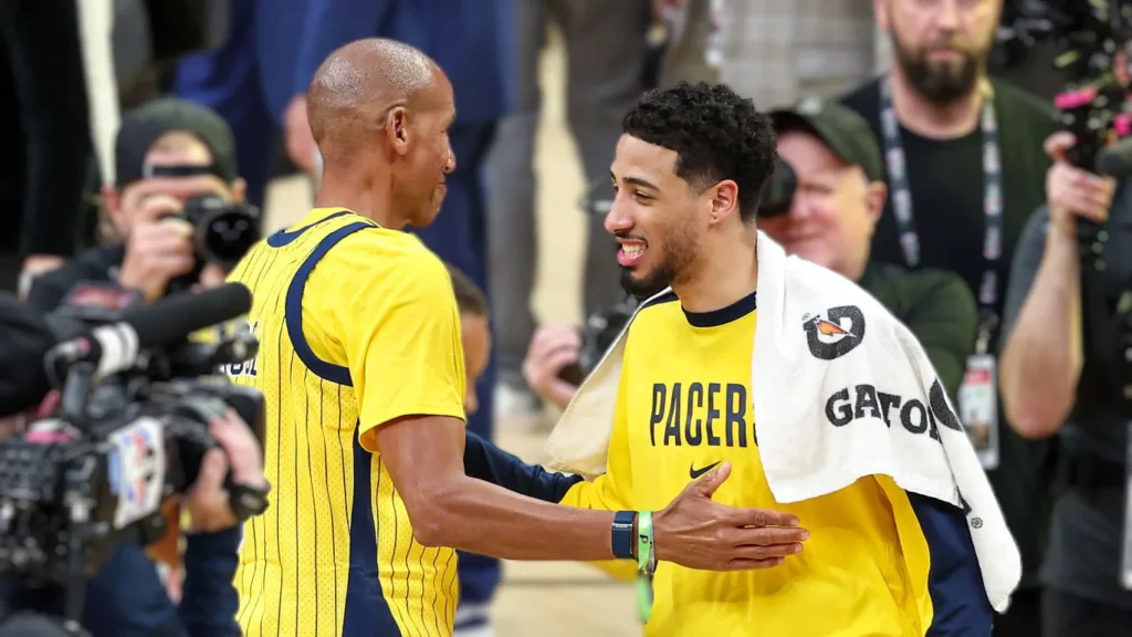 Indiana Pacers legend Reggie Miller shares a moment with current star Tyrese Haliburton, symbolizing the passing of the torch and mutual respect between the franchise's past and present.